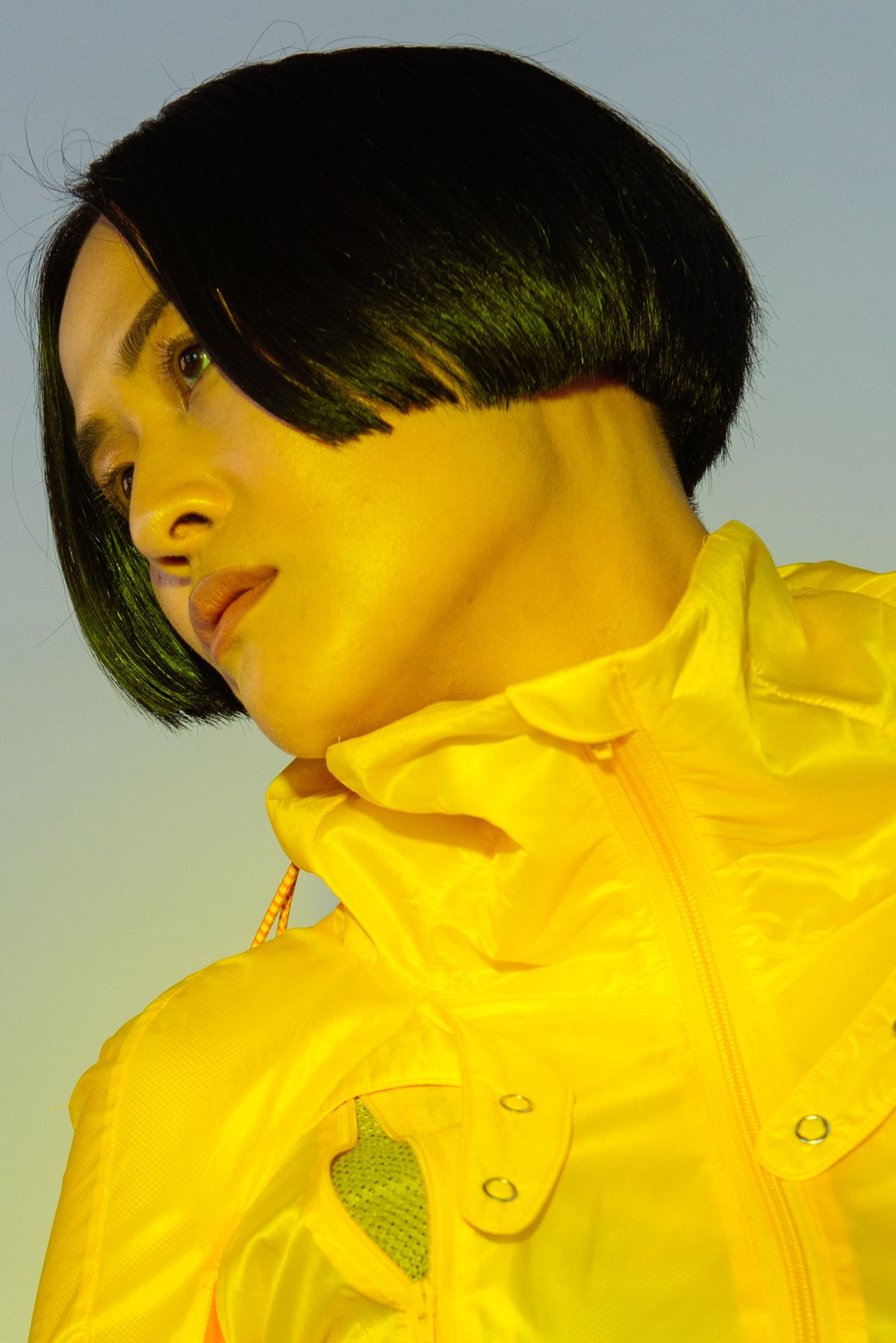 A woman with a bob in a fluoro yellow jacket
