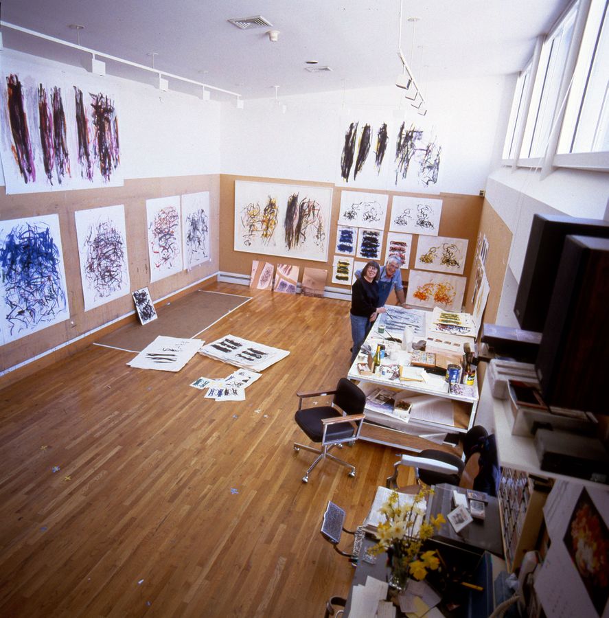 Photo of Joan Mitchell and Kenneth Tyler in studio with artwork on walls