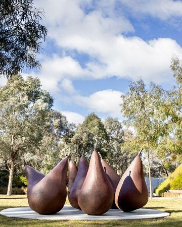A group of seven brown metal pear sculptures