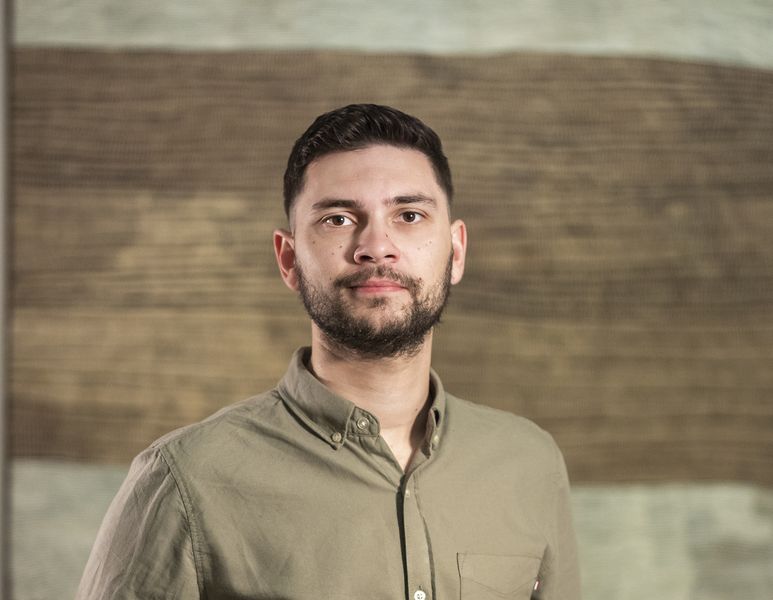 Portrait of a man standing in front of artwork in an Art Gallery