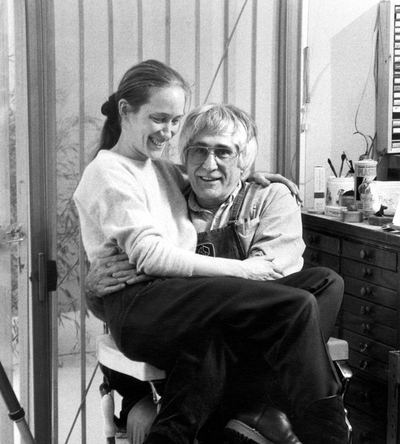 A man sits on a chair with a woman sitting on his lap