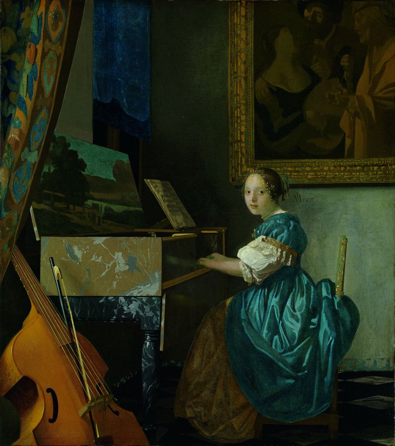 A young woman in a blue dress sits at a virginal