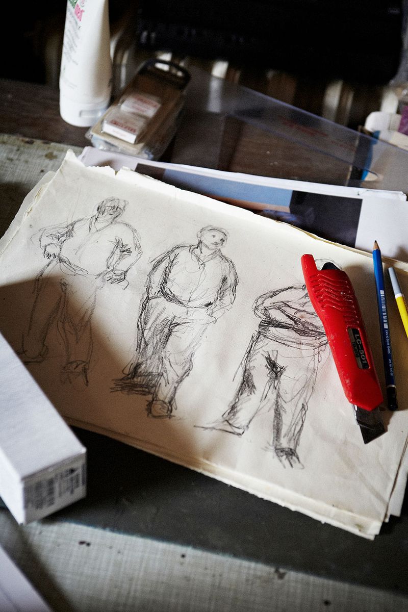 A photograph of three sketches of a figure standing