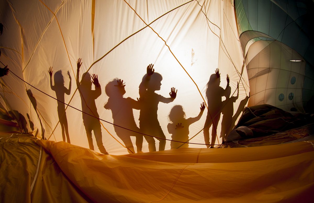 Photograph of balloon with silhouettes of kids playing