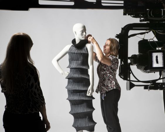 Photograph of black dress on mannequin being photographed behind the scenes