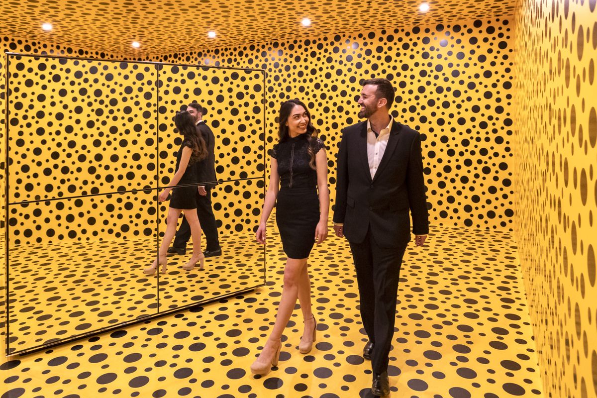 Photograph of couple walking through yellow and black spotted space