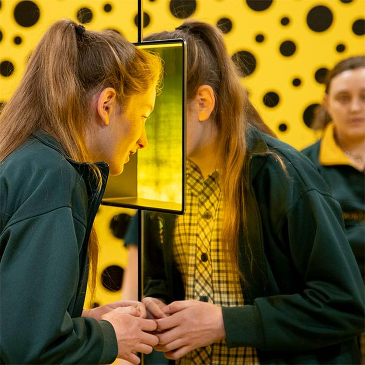 Secondary school aged girl looking through through a window as part of an installation