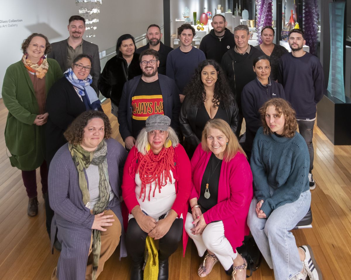 A group of people pose in a group facing the camera to have their photo taken