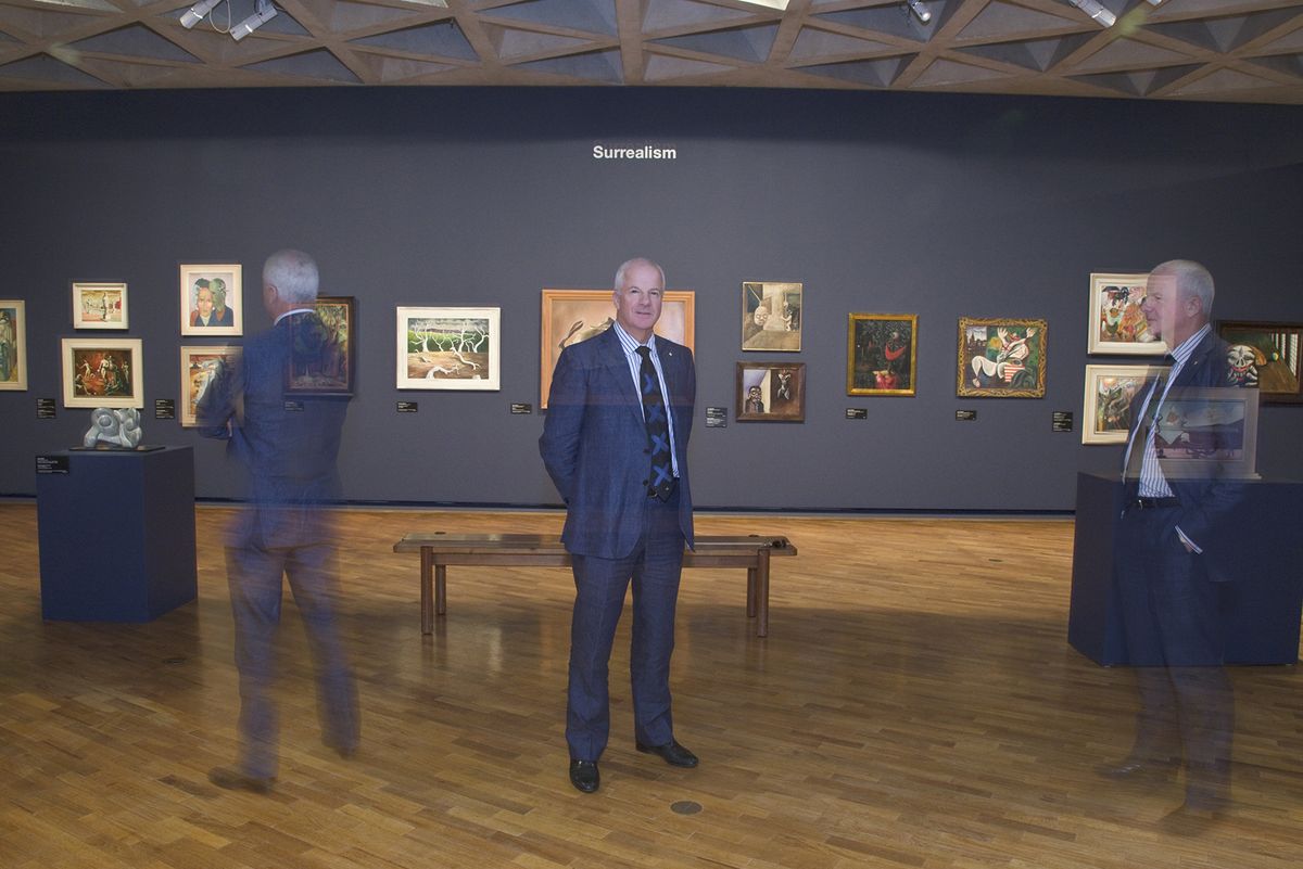 Three versions of a man stand in an art gallery