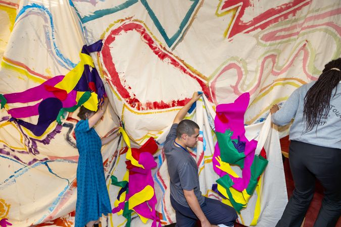 Photograph of young people holding up coloured art piece